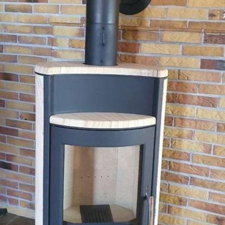 Neuer Kaminofen vor einer Backsteinwand